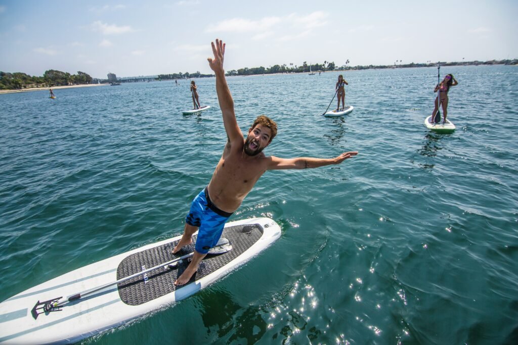 Person paddle boarding on calm water for a full-body fitness workout